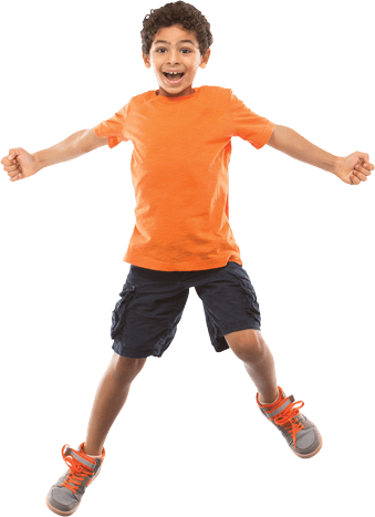 A smiling child jumping in the air, arms stretched out to the side.